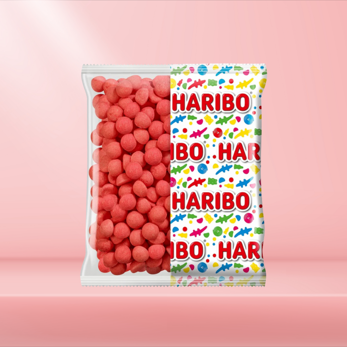 Boîte de Fraises Tagada Haribo sur fond rose, bonbons rouges moelleux au goût de fraise.