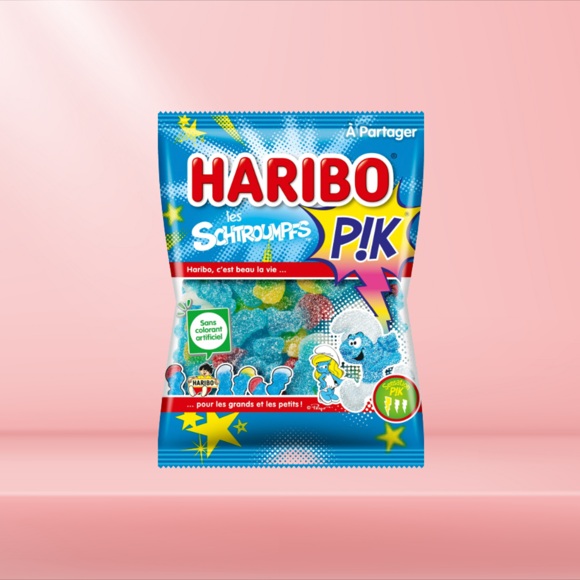 Sachet de bonbons Haribo Schtroumpfs Pik, bonbons fruités et acidulés inspirés des Schtroumpfs, sur fond rose.