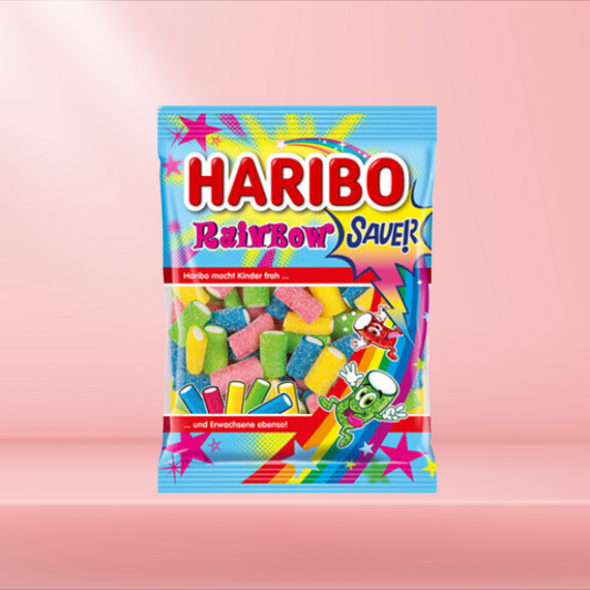 Sachet de bonbons Haribo Rainbow, assortiments de bandes fruitées et acidulées, sur fond rose.